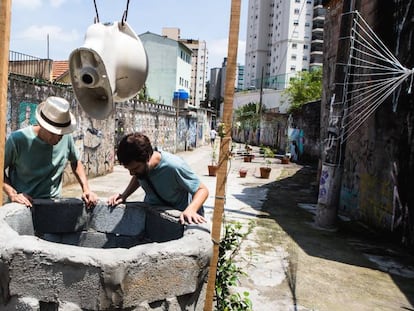 Adriano Sampaio, do Existe Água em SP, e o artista Flavio Barollo, do grupo (se)cura humana, observam o córrego Água Preta, em São Paulo