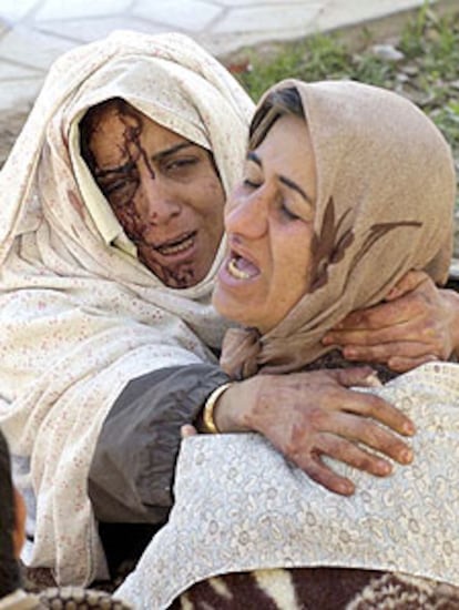 Dos mujeres heridas se abrazan tras el terremoto que sacudió ayer la ciudad iraní de Bam.