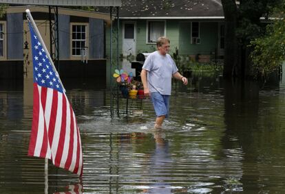 Un hombre camina entre el agua que ha inundado parte de Sorrento, Luisiana (EE.UU).