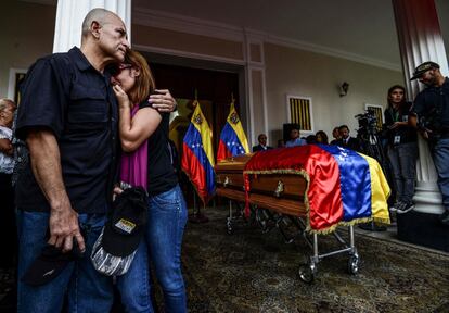 Miembros del partido opositor venezolano lloran durante la entrada del ataúd al edificio de la Asamblea Nacional.