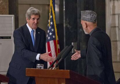 John Kerry (izquierda) y Hamid Karzai se estrechan la mano al final de su rueda de prensa en Kabul.