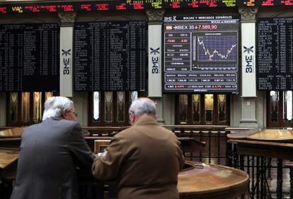 Dos inversores asiduos al palacio de la Bolsa de Madrid conversan.