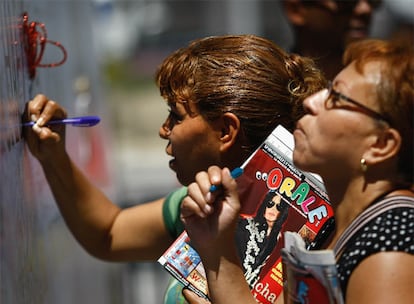 Dos mujeres dejan sus mensajes en honor a Jackson en uno de los muros del Staples Center