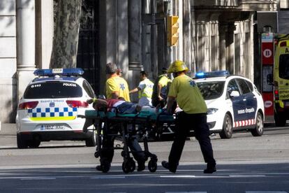 Los servicios de emergencia trasladan a una de las personas afectadas por el atropello de una furgoneta esta tarde por las Ramblas de Barcelona, en un atropello masivo.