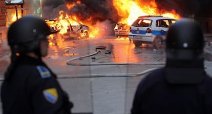 Polic&iacute;as bosnios intentan impedir el pasado viernes un ataque de manifestantes.