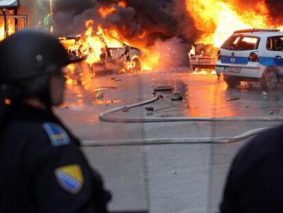 Polic&iacute;as bosnios intentan impedir el pasado viernes un ataque de manifestantes.