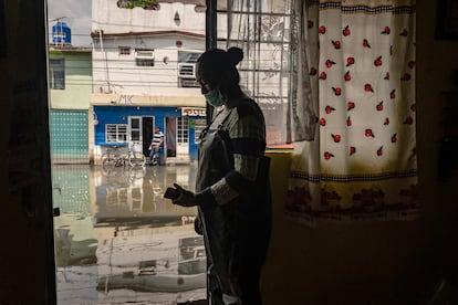 Yazmín Mendoza Ramírez observa una calle inundada de aguas negras desde su hogar tras más de 20 días atrapados en las inundaciones, ocasionadas por el colapso de los drenajes, a causa de la suciedad y las fuertes lluvias en la colonia Culturas de México, en el municipio de Chalco, Estado de México. El 27 de agosto de 2024.