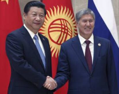 El presidente de China, Xi Jinping (i), estrecha la mano de su homólogo kirguizo, Almazbek Atambayev, durante la cumbre de la Organización de Cooperación de Shanghái (SCO) en el Gran Palacio del Pueblo, en Biskek (Kirguizistán) ayer.