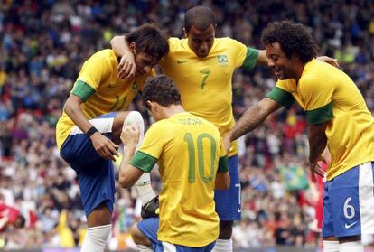 Oscar, en el festejo de un gol de Brasil, hace de limpiabotas de Neymar.