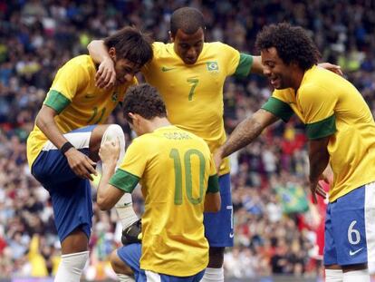 Oscar, en el festejo de un gol de Brasil, hace de limpiabotas de Neymar.