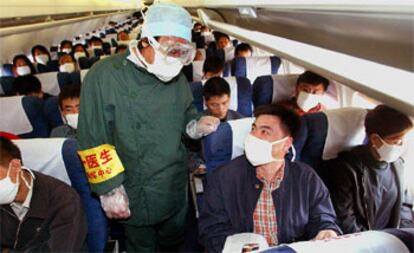 Un médico controla los pasajeros de un avión tras haber embarcado en el aeropuerto de Shenyang (China) para detectar posibles viajeros con neumonía.