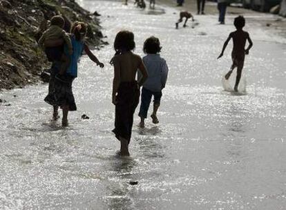 Varios niños chapotean en una zona inundada de la Cañada Real.