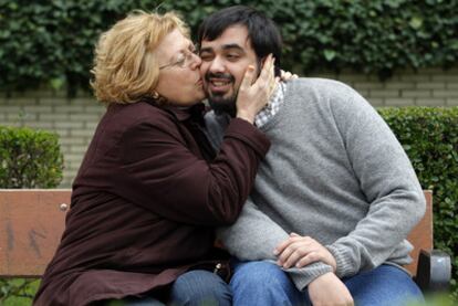 Carmen Rodríguez, en un jardín próximo a su casa de Leganés, besa a David, el hijo que adoptó en 1981 en la clínica San Ramón de Madrid.