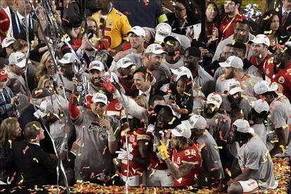 Patrick Mahomes levanta o troféu cercado por sua equipe depois da vitória no Super Bowl.