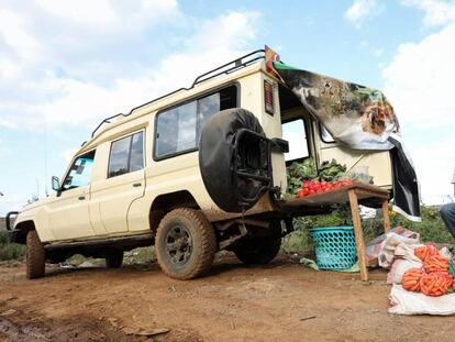 El guía de safari keniano Michael Kimani empaqueta zanahorias en bolsas junto a su coche, reconvertido en una frutería ambulante. Desde que la pandemia le dejó sin trabajo, esta es su nueva manera de ganarse la vida.    
