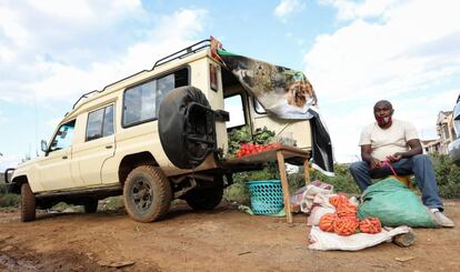 El guía de safari keniano Michael Kimani empaqueta zanahorias en bolsas junto a su coche, reconvertido en una frutería ambulante. Desde que la pandemia le dejó sin trabajo, esta es su nueva manera de ganarse la vida.    