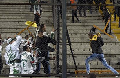 Aficionados del equipo brasileño del Palmeiras (izda.), se enfrentan a los aficionados del Peñarol de Uruguay al final del partido de la Copa Libertadores que ganó el equipo brasileñó por 3 goles a 2, en Montevideo (Uruguay).