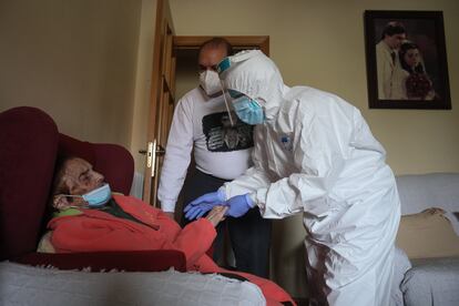 La enfermera Susana Cámara atiende a Ana, de 93 años, enferma de covid, en su casa en Villaverde (Madrid).