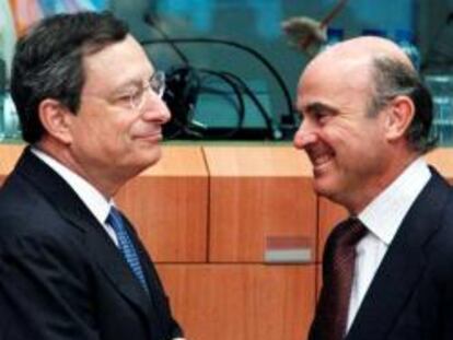 El presidente del BCE, Mario Draghi, escucha la ministro español de Economía, Luis de Guindos (derecha) durante la reunión del Eurogrupo