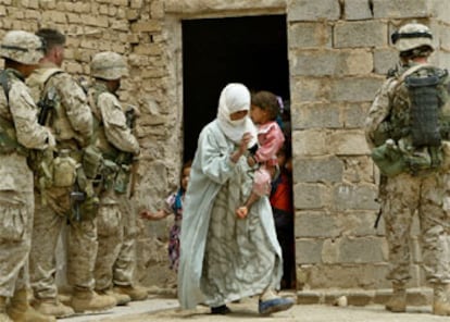 Una mujer sale de una vivienda que va a ser registrada por <i>marines</i> de EE UU  durante una operación en un pueblo cercano a Faluya.