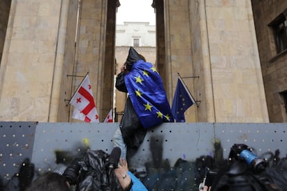 Un manifestante intentan cruzar la valla del Parlamento, durante las protestas de este martes en Tbilisi (Georgia).