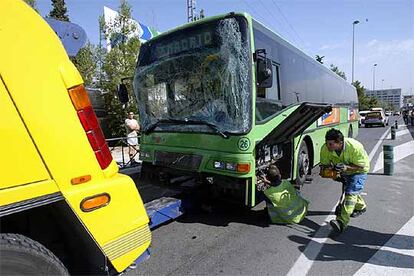 Empleados de la grúa se disponen a remolcar uno de los autobuses implicados en el accidente de la A-1.