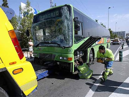 Empleados de la grúa se disponen a remolcar uno de los autobuses implicados en el accidente de la A-1.