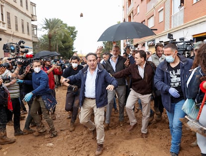 The entourage of King Felipe and other officials advance through the streets of Paiporta while onlookers hurl mud at them.