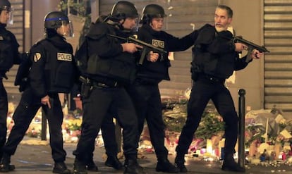 Policías cerca del restaurante Le Carrillon se preparan para actuar ante un vehículo sospechosos.
