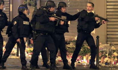 Polic&iacute;as cerca del restaurante Le Carrillon se preparan para actuar ante un veh&iacute;culo sospechosos. 