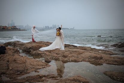 Una pareja de jóvenes chinos se besa frente al Mar Amarillo, en Qingdao (China), para sus fotos antes de la boda, el 15 de abril de 2017.