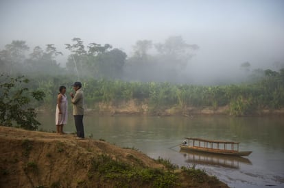 Miembros de una comunidad conversan frente al río Purus en Ucayali, Perú.