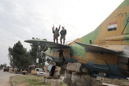 Un combatiente rebelde hace el gesto de la victoria sobre un avión militar de las fuerzas leales al gobierno de Bachar el Asad, en el aeropuerto militar de Hama, después de que los rebeldes sirios lucharan el sábado contra las fuerzas gubernamentales por el control de la ciudad clave de Homs.