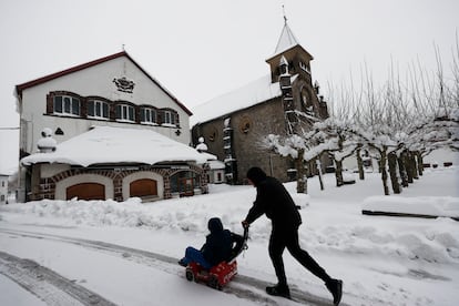 Dos niños disfrutan con sus trineos entre la nieve acumulada en la localidad de Burguete.