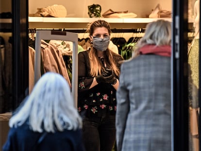 Una dependienta espera la entrada de clientes el primer día de reapertura de las tiendas en Essen, al oeste de Alemania.