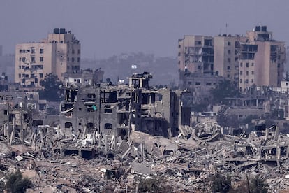 Imagen tomada desde el sur de Israel muestra banderas israelíes ondeando sobre edificios destruidos dentro de la Franja de Gaza, este domingo. 