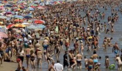 Los ba&ntilde;istas abarrotan la Playa de la Malvarrosa en Valencia. 