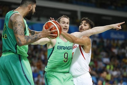 Ricky Rubio (direita) de España diante do brasileiro Augusto Lima (esquerda) na partida de basquete. Brasil ganhou o jogo apertado da boa seleção espanhola, com a estrela Paul Gasol.