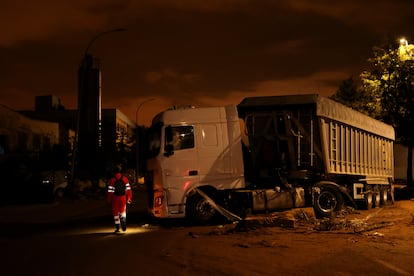 Trabajadores de emergencias pasan junto a un camión varado en Paiporta, cerca de Valencia.