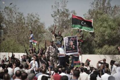 Combatientes rebeldes sostienen una fotografía de Abdel Fatah Yunis, en su entierro.