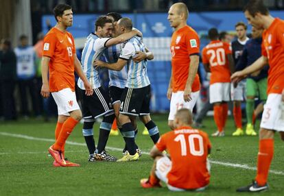 Los jugadores argentinos Ezequiel Garay, Javier Mascherano y Lucas Biglia festejan su triunfo mientras los holandeses muestran su decepci&oacute;n.