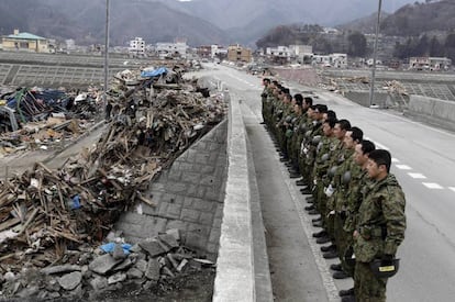 Soldados japoneses rezan por las víctimas en la ciudad costera de Otsuchi, Iwate. Un total de 14.377 personas siguen desaparecidas, según el último recuento de la Policía nipona.