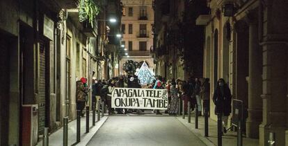 “Apaga la tele y okupa tú también”, reza la pancarta de unos okupas que se manifestaban en Barcelona en una imagen de archivo.