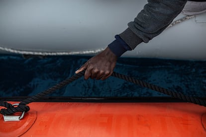 Ali, de origen marfileño se coge a la lancha de rescate; la avería del motor ha provocado el naufragio del hinchable en aguas internacionales. Según Safa Msehli, portavoz de la Organización Mundial para las Migraciones (OIM), en las últimas semanas cerca de 2.000 personas han sido interceptadas en el mar por las autoridades costeras, y devueltas a Libia.