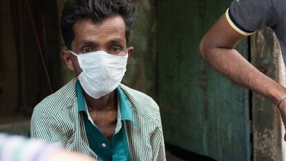Varios trabajadores sociales atienden en la calle a un enfermo contagioso de tuberculosis.