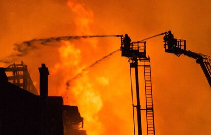 Bomberos trabajan para apagar el fuego en la sede de la escuela de arte de Glasgow, hoy, 16 de junio. 