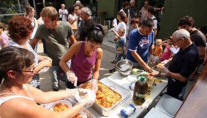 Padres de los alumnos de Vilobí dOnyar reparten la comida en el comedor provisional.