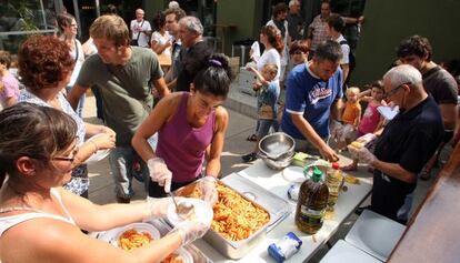 Padres de los alumnos de Vilob&iacute; dOnyar reparten la comida en el comedor provisional.