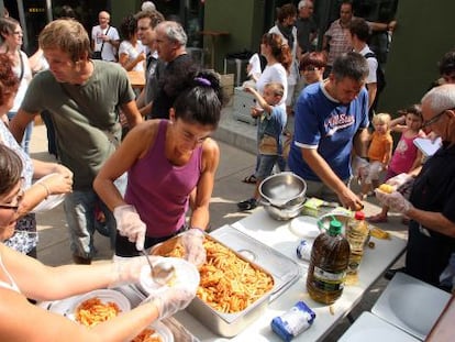 Padres de los alumnos de Vilob&iacute; dOnyar reparten la comida en el comedor provisional.