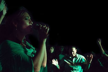 A pastora Rosania Rocha canta durante o culto. Ao fundo, sua esposa, a pastora Lanna Holder.